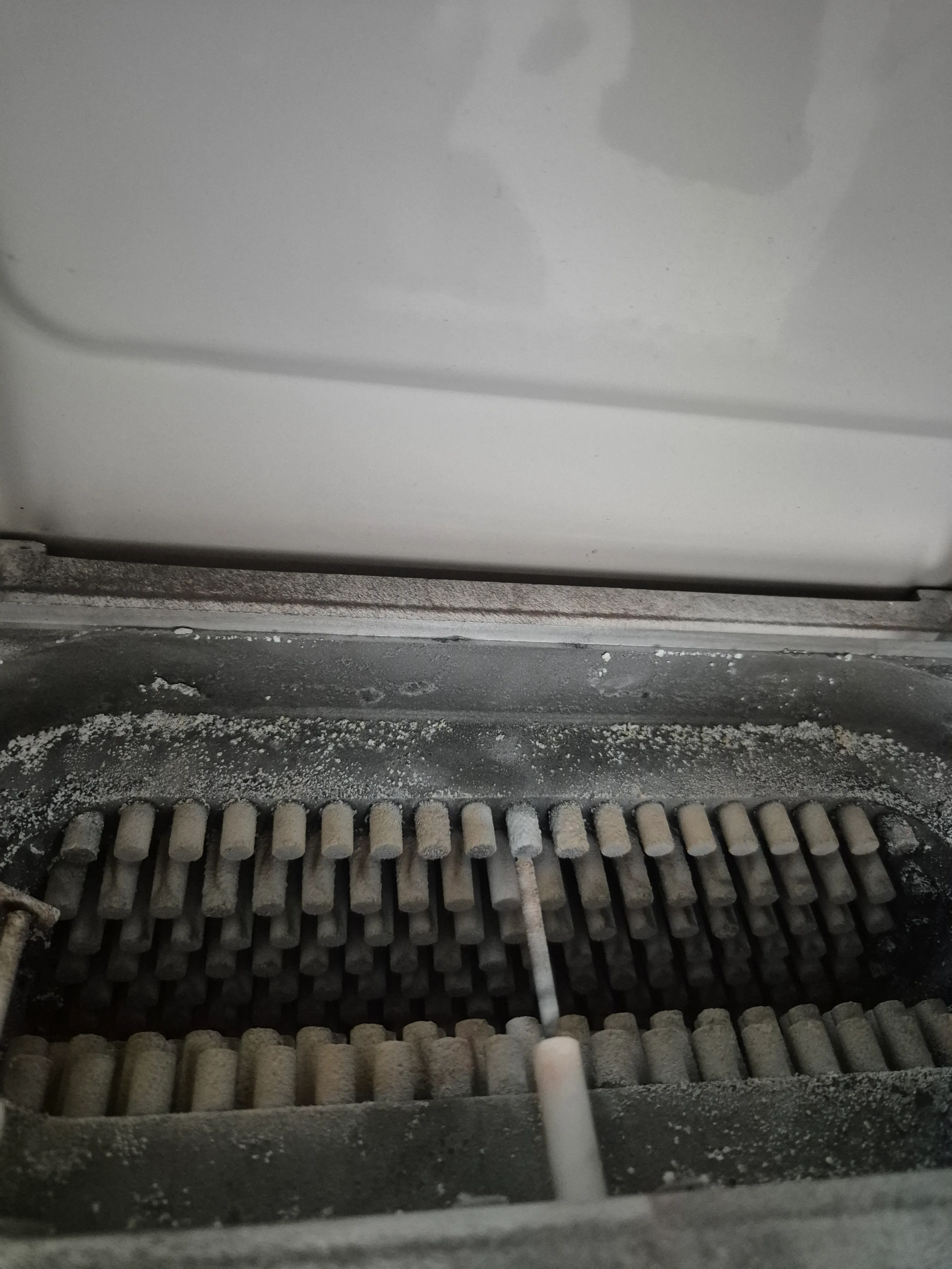 Indoor AC unit heat exchanger before cleaning — dust and dirt on the fins