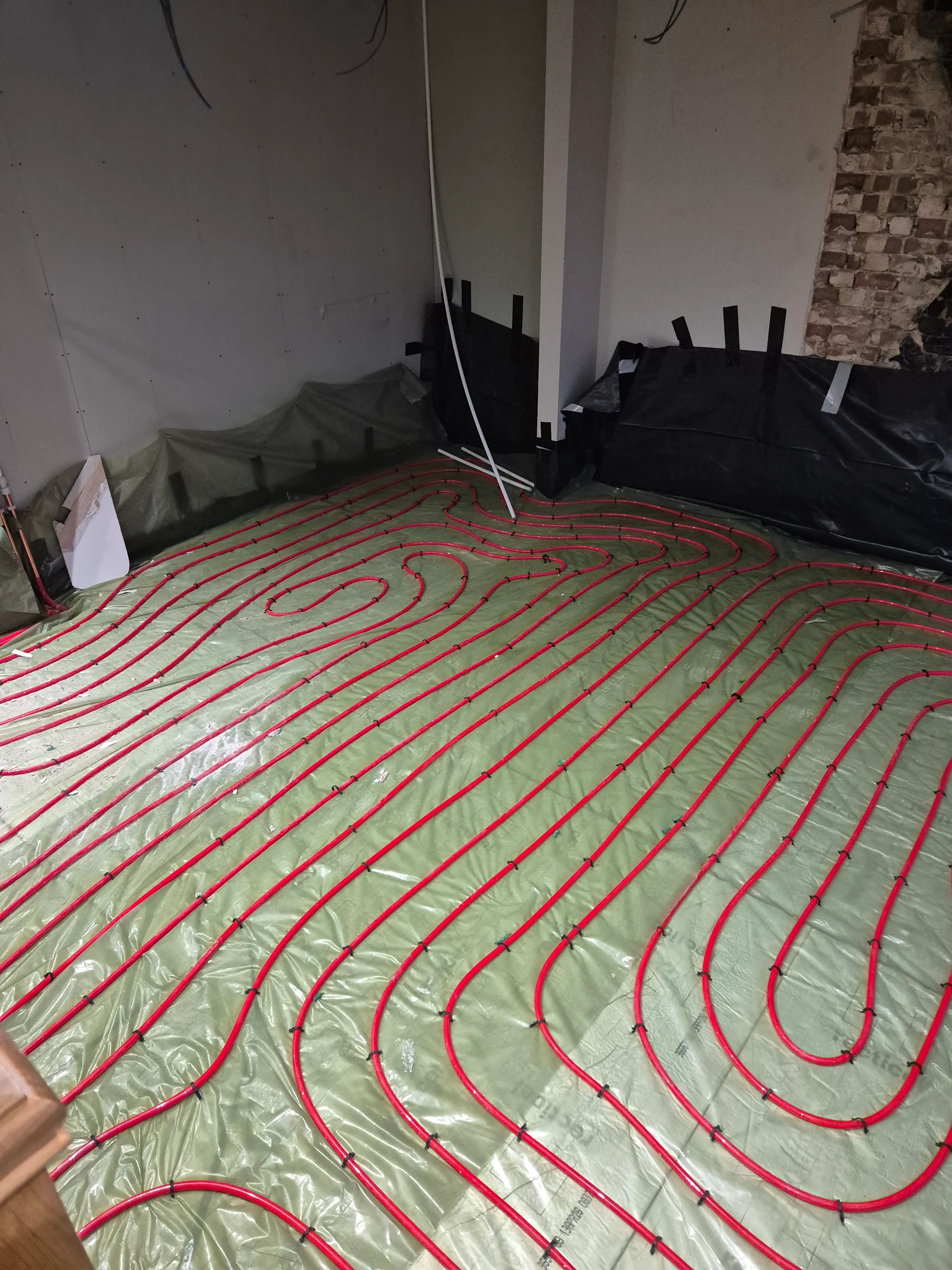 Underfloor heating loops — close-up of pipe runs and manifold connection