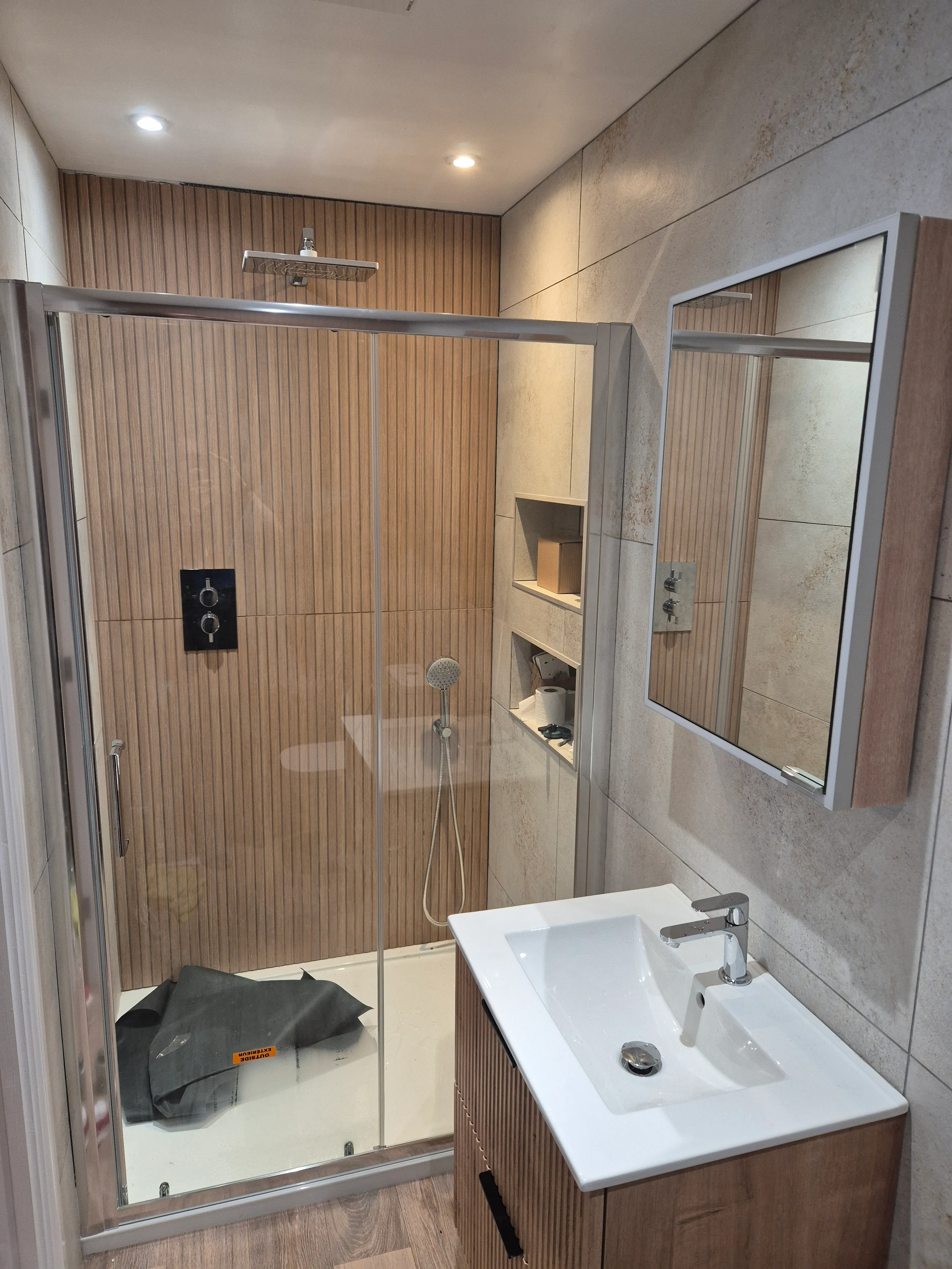 Finished bathroom — wall-hung WC and vanity unit on large-format tiles