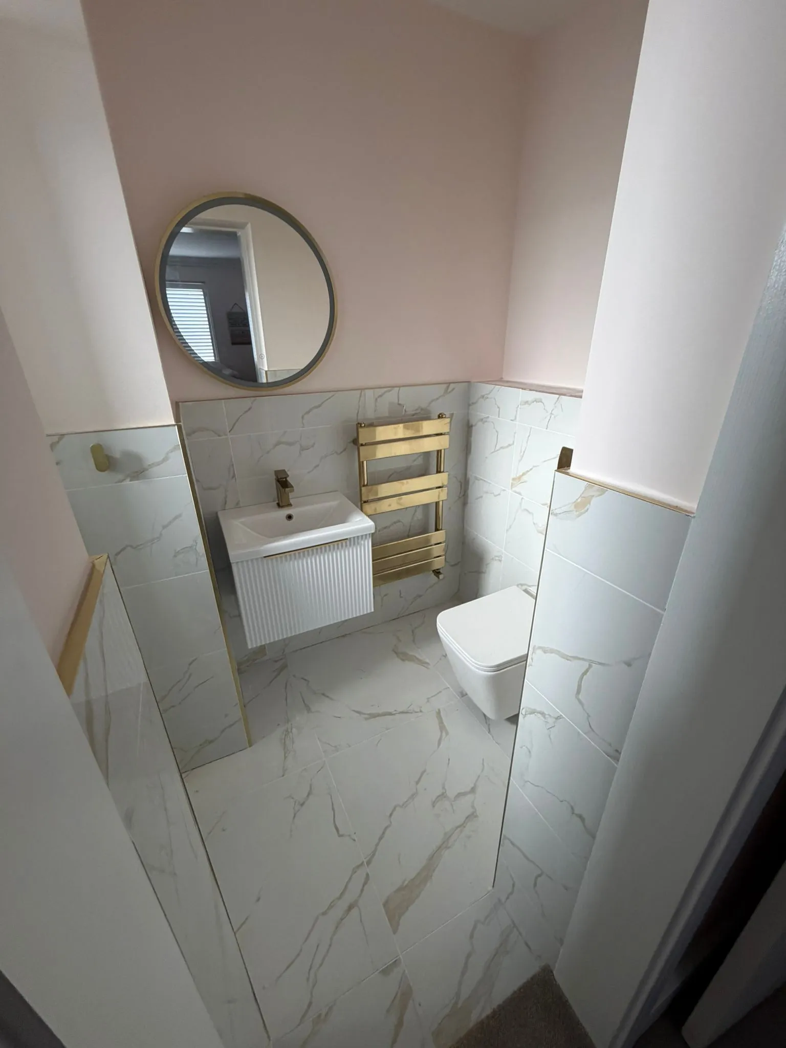 Same bathroom — wider angle showing the towel rail and full tile run